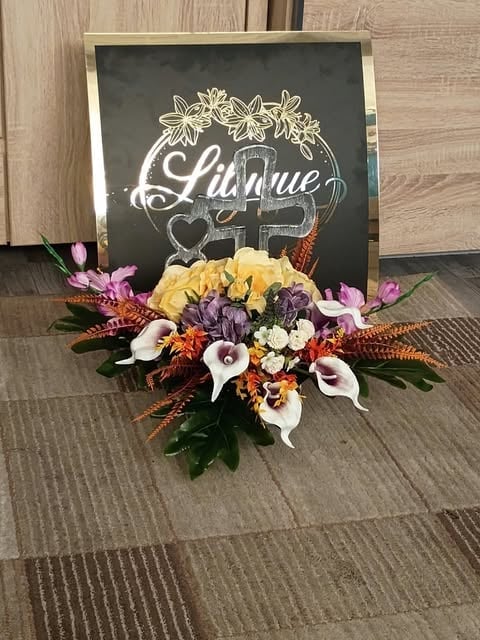 A colorful flower arrangement sits in front of a chalkboard sign that reads Lilianne with decorative floral designs