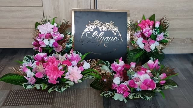 Four floral arrangements with pink and white flowers arranged around a black sign reading Boutique on a wooden floor