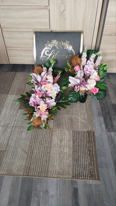 Floral arrangement with pink and white flowers next to a chalkboard sign on a gray tile floor