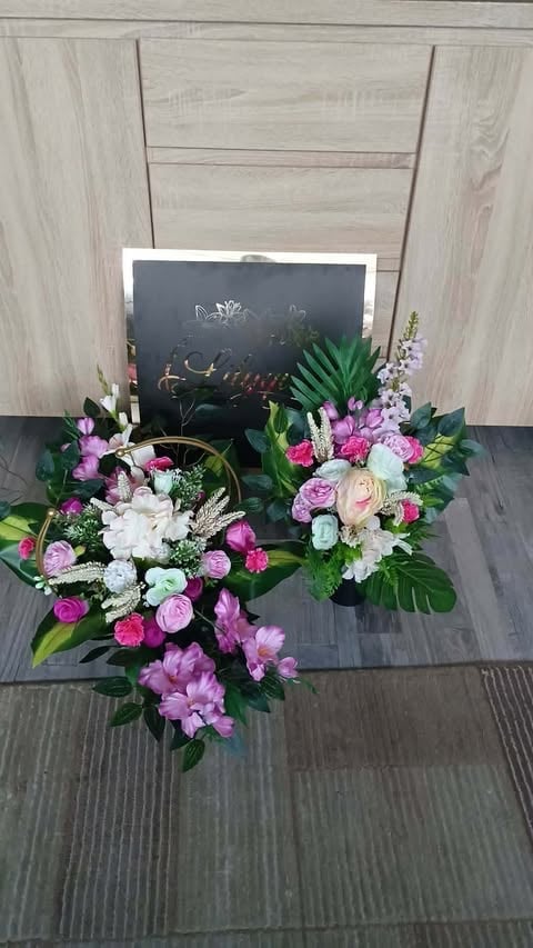 Vibrant floral arrangement with pink roses, white flowers, and green foliage displayed with a chalkboard on wooden background