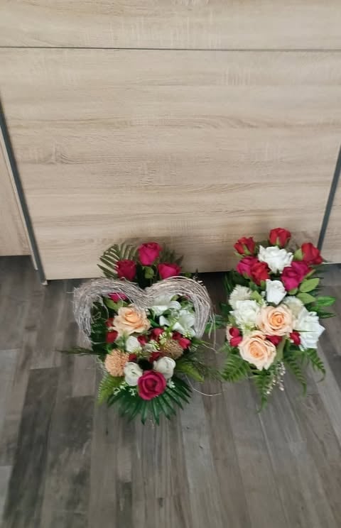 Three floral arrangements on gray laminate flooring featuring roses, carnations, and greenery in red, pink, white, and coral colors