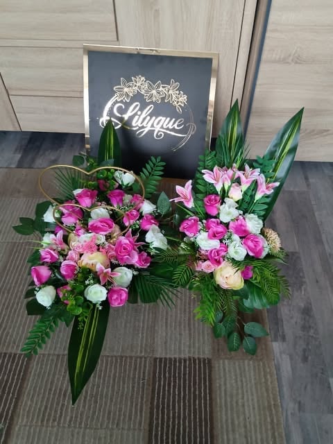 Floral arrangement with pink, white, and peach roses and lilies on striped floor with chalkboard sign reading Chique in background