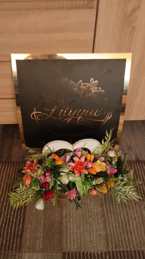 Wedding guest book with ornate lounge sign and colorful floral arrangement at base
