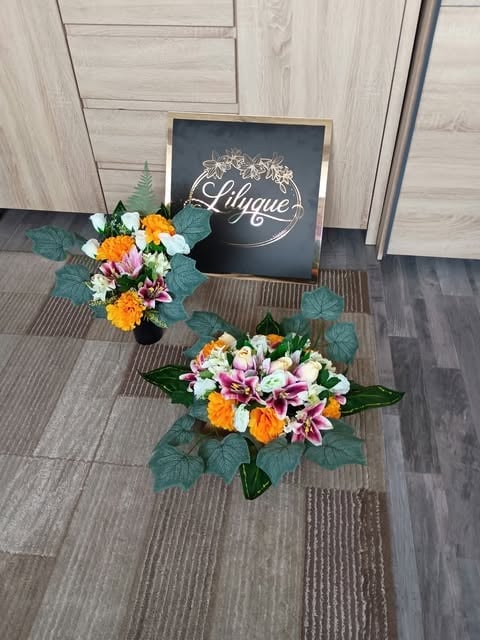 Colorful flower arrangements with pink, yellow, and white blooms displayed on gray tile flooring next to a black Lyrique sign