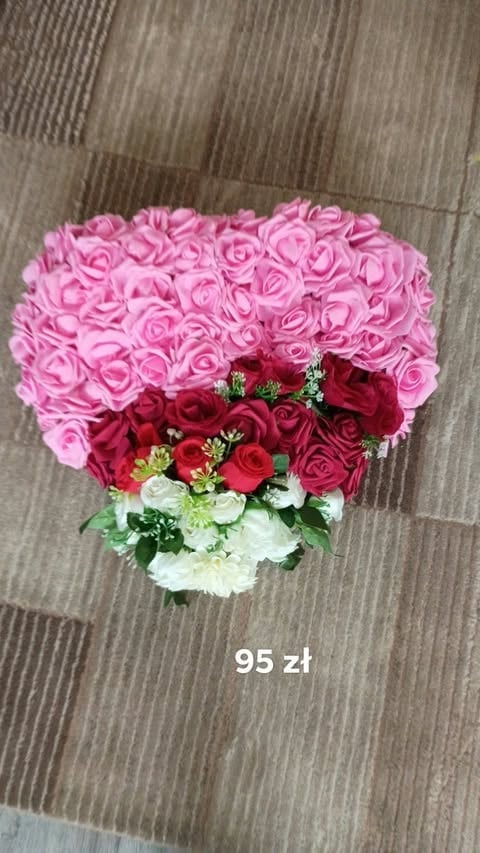Heart-shaped bouquet of pink, red, and white roses on wooden floor with 95 zl price tag