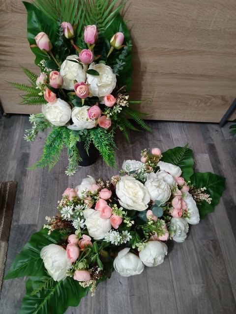 Two floral arrangements with white peonies, pink roses, and greenery on wooden floor